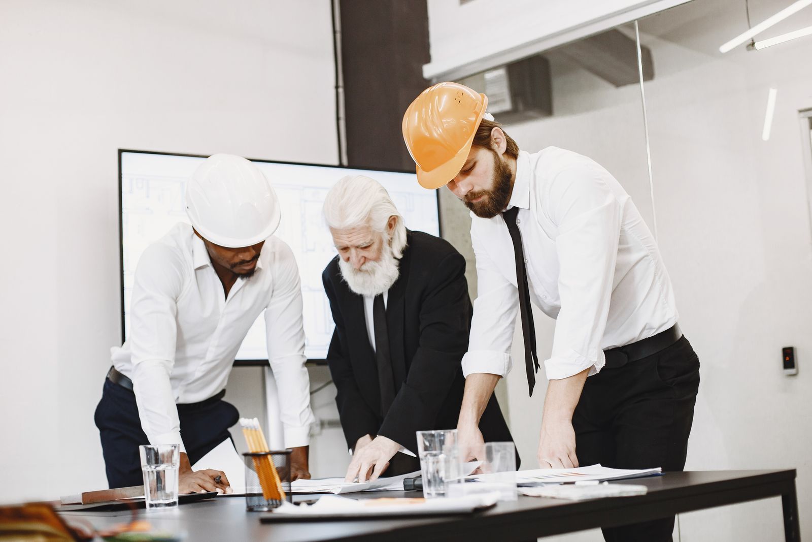 Property professionals comparing architectural plans and project evidence