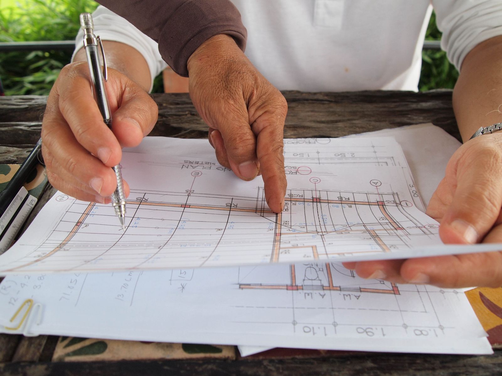 Calculator and documents laid over architectural plans